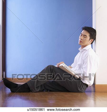 Side profile of a businessman sitting on the floor with a laptop View Large Photo Image Stock Image - Side profile of a businessman sitting on the floor with a laptop. Fotosearch
