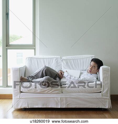 Stock Photo - Side profile of a young man sleeping on a couch. Fotosearch