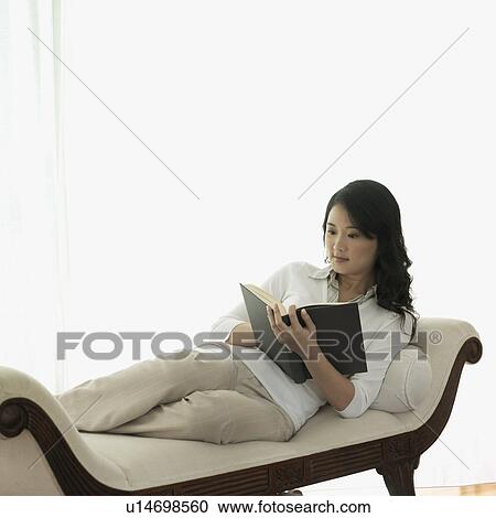 Stock Image - Young woman reading a book. Fotosearch