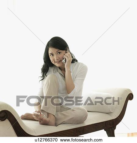 Stock Image - Young woman talking on a mobile phone. Fotosearch