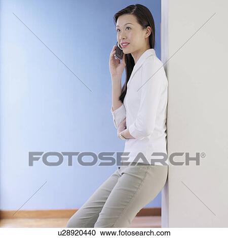 Stock Image - Young woman talking on a mobile phone. Fotosearch