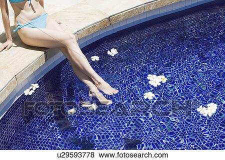 Elevated view of a woman sitting beside swimming pool View Large Photo Image Stock Photo - Elevated view of a woman sitting beside swimming pool. Fotosearch