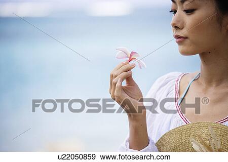A woman holding hat and flower View Large Photo Image Stock Photo - A woman holding hat and flower. Fotosearch