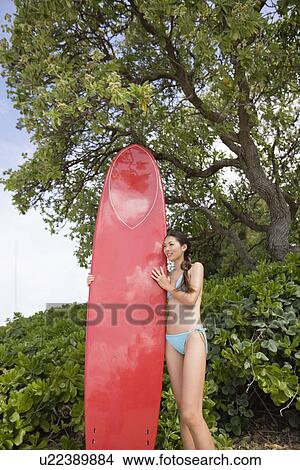 A woman holding surfboard View Large Photo Image Picture - A woman holding surfboard. Fotosearch