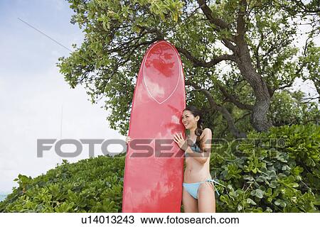 A woman holding surfboard View Large Photo Image Stock Image - A woman holding surfboard. Fotosearch