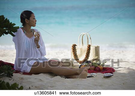 A woman holding wineglass at beach looking away View Large Photo Image Stock Image - A woman holding wineglass at beach looking away. Fotosearch