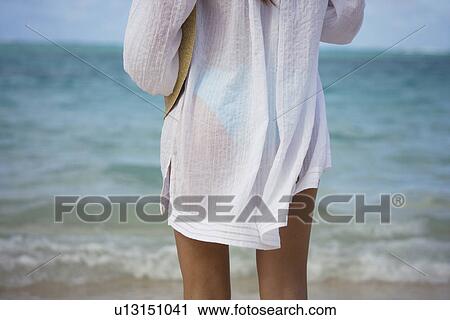 Stock Image - A woman standing on beach. Fotosearch