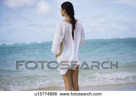 Stock Photograph - A woman standing on beach. Fotosearch