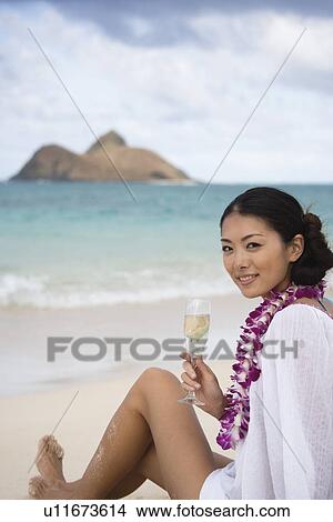 A young woman holding wineglass at beach View Large Photo Image Picture - A young woman holding wineglass at beach. Fotosearch