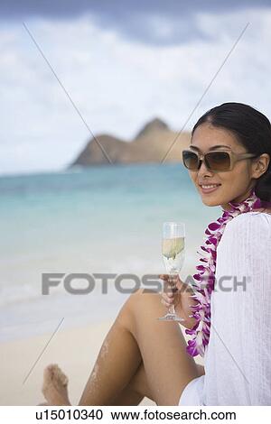 A young woman holding wineglass at beach View Large Photo Image Stock Image - A young woman holding wineglass at beach. Fotosearch