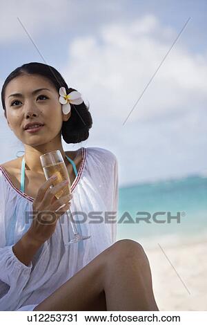 Stock Image - A young woman holding wineglass. Fotosearch
