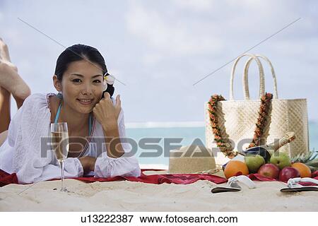 Stock Photo - A young woman lying at beach. Fotosearch