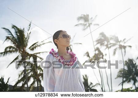 Picture - A young woman wearing sunglasses. Fotosearch