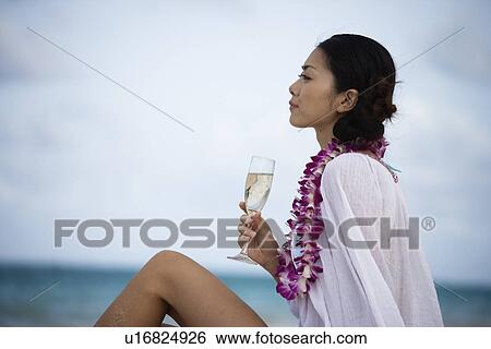 Stock Photograph - Profile of a young woman holding wineglass. Fotosearch