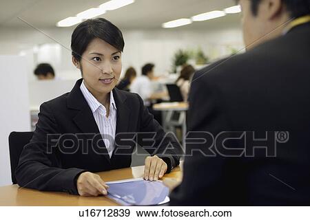 Stock Photo - A woman having a professional meeting in the office. Fotosearch