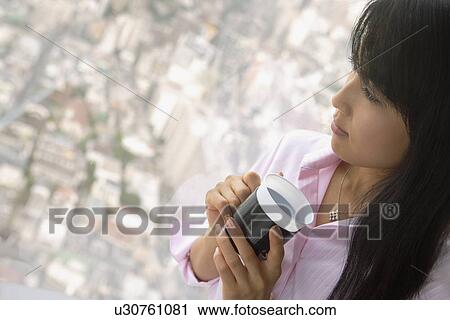 Stock Image - A woman in her thoughts as she has a cup of coffee. Fotosearch