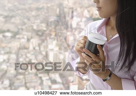 A woman in her thoughts as she has a cup of coffee View Large Photo Image Stock Photo - A woman in her thoughts as she has a cup of coffee. Fotosearch