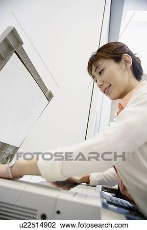 Stock Image - A woman operating a Xerox machine. Fotosearch
