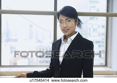 A woman standing beside the window as she smiles at the camera View Large Photo Image Picture - A woman standing beside the window as she smiles at the camera. Fotosearch