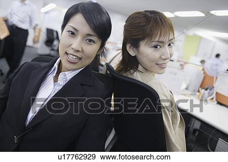 Stock Photo - Two women sitting opposite to each other and looking at the camera. Fotosearch