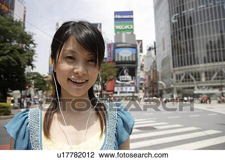 Portrait of a young woman listening to music View Large Photo Image Stock Image - Portrait of a young woman listening to music. Fotosearch