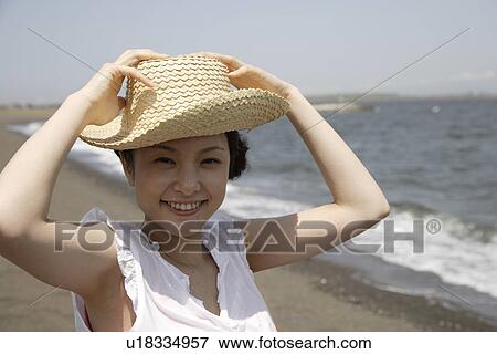 Stock Photo - Portrait of a young woman on beach. Fotosearch