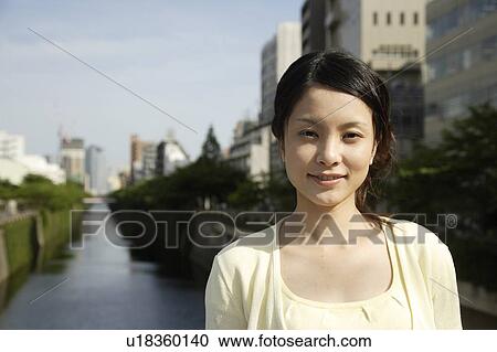 Portrait of a young woman smiling with canal in background View Large Photo Image Stock Image - Portrait of a young woman smiling with canal in background. Fotosearch