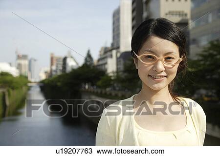 Portrait of a young woman smiling with canal in background View Large Photo Image Stock Image - Portrait of a young woman smiling with canal in background. Fotosearch