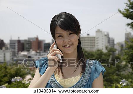 Portrait of a young woman talking on mobile phone View Large Photo Image Picture - Portrait of a young woman talking on mobile phone. Fotosearch