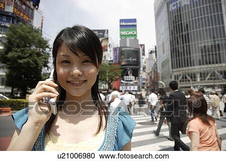 Stock Image - Portrait of a young woman talking on mobile phone. Fotosearch