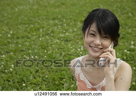 Stock Photograph - Portrait of a young woman talking on mobile phone. Fotosearch