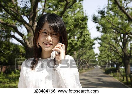 Stock Photograph - Portrait of a young woman talking on mobile phone. Fotosearch