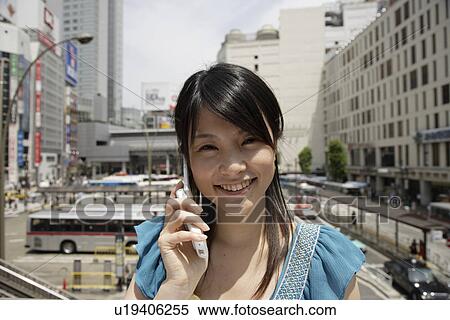 Stock Photography - Portrait of a young woman talking on mobile phone. Fotosearch