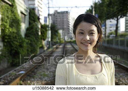 Portrait of a young woman with railway track in background View Large Photo Image Stock Image - Portrait of a young woman with railway track in background. Fotosearch