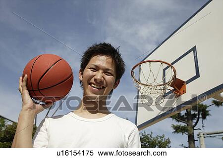Portrait of a young man holding basketball View Large Photo Image Stock Photography - Portrait of a young man holding basketball. Fotosearch