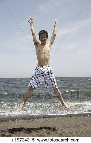 Portrait of a young man jumping on beach View Large Photo Image Stock Photography - Portrait of a young man jumping on beach. Fotosearch