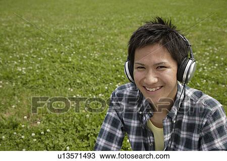 Stock Image - Portrait of a young man listening to music. Fotosearch