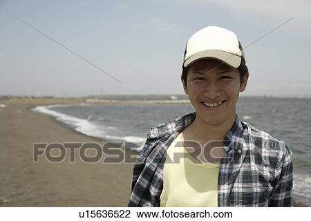 Stock Image - Portrait of a young man on beach. Fotosearch