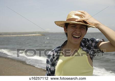 Stock Image - Portrait of a young man on beach. Fotosearch
