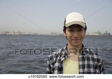 Stock Image - Portrait of a young man on beach. Fotosearch
