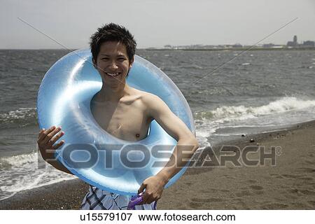 Portrait of a young man on beach with a lifebuoy View Large Photo Image Stock Photo - Portrait of a young man on beach with a lifebuoy. Fotosearch