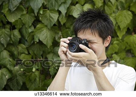 Portrait of a young man photographing View Large Photo Image Picture - Portrait of a young man photographing. Fotosearch