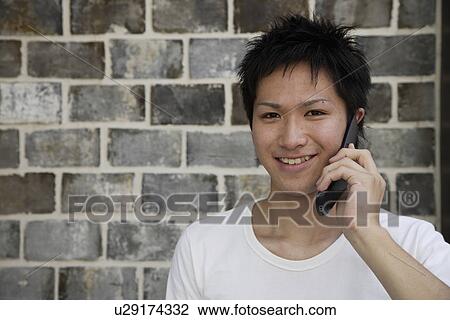 Portrait of a young man talking on mobile phone View Large Photo Image Stock Image - Portrait of a young man talking on mobile phone. Fotosearch