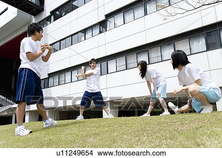 Picture - Four teenagers in gym clothes stretching on lawn. Fotosearch