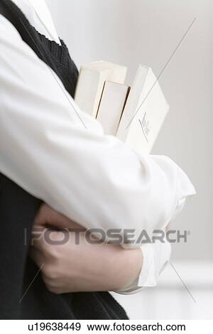 Stock Photo - Girl holding textbooks, side view, close up, white background. Fotosearch