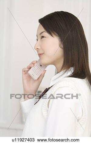Girl using mobile phone, smiling, side view View Large Photo Image Stock Image - Girl using mobile phone, smiling, side view. Fotosearch