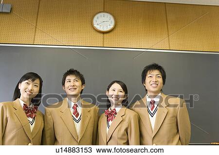 Stock Image - High School Students Standing and Smiling in front of Blackboard. Fotosearch