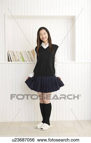 Stock Photograph - Portrait of a girl in school uniform, smiling and looking at camera, front view. Fotosearch