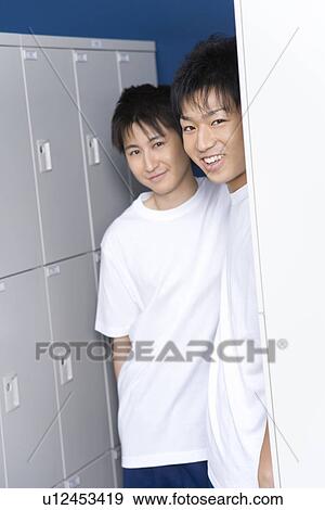 Stock Photo - Portrait of teenage boys in gym clothes standing in locker room, smiling and looking at camera. Fotosearch