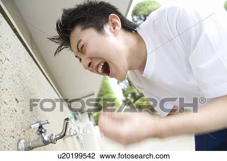 Stock Image - Teenage boy in gym cloth washing face and yelling, blurred motion. Fotosearch